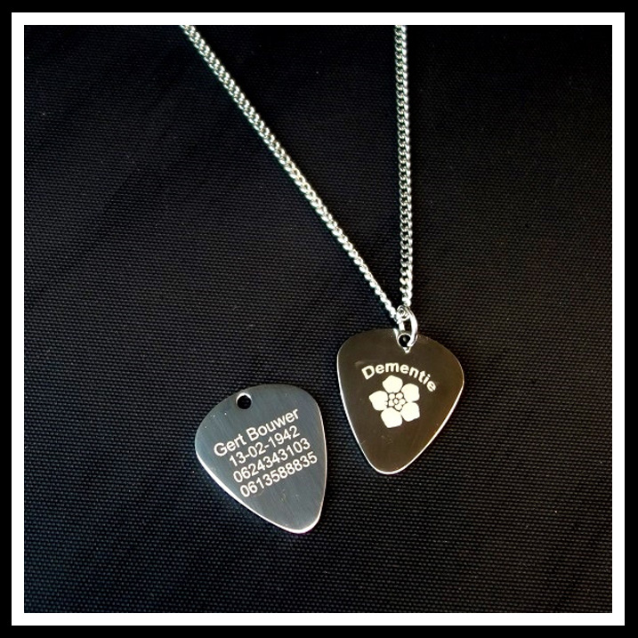 Alzheimer of dementie ketting guitar pick, 2 zijde gravure met aan de voorzijde een vergeet mij niet bloem en de tekst alzheimer of dementie. Aan de achterzijde 4 regels tekst. Inclusief rvs ketting naar keuze.