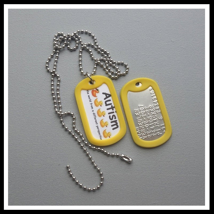 Dogtag met sticker autsime, ADHD, of epilepsie voorzijde. Aan de achterzijde 6 regels tekst geponst.