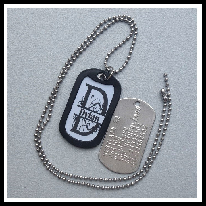 Dogtag met sticker naam in sierlijk monogram. Achterzijde 6 regels tekst, inclusief balletjesketting